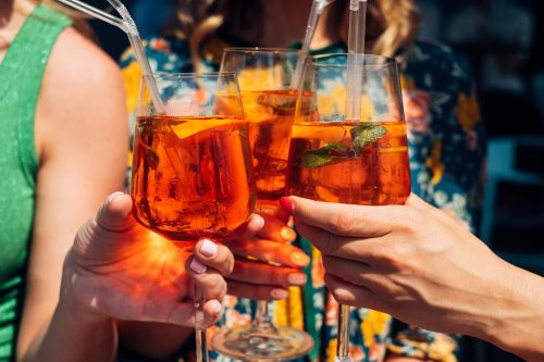 Friends toasting with aperol spritz cocktails