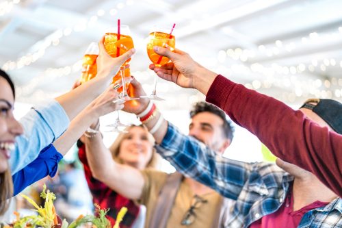 People toasting spritz drink at fashion cocktail bar restaurant